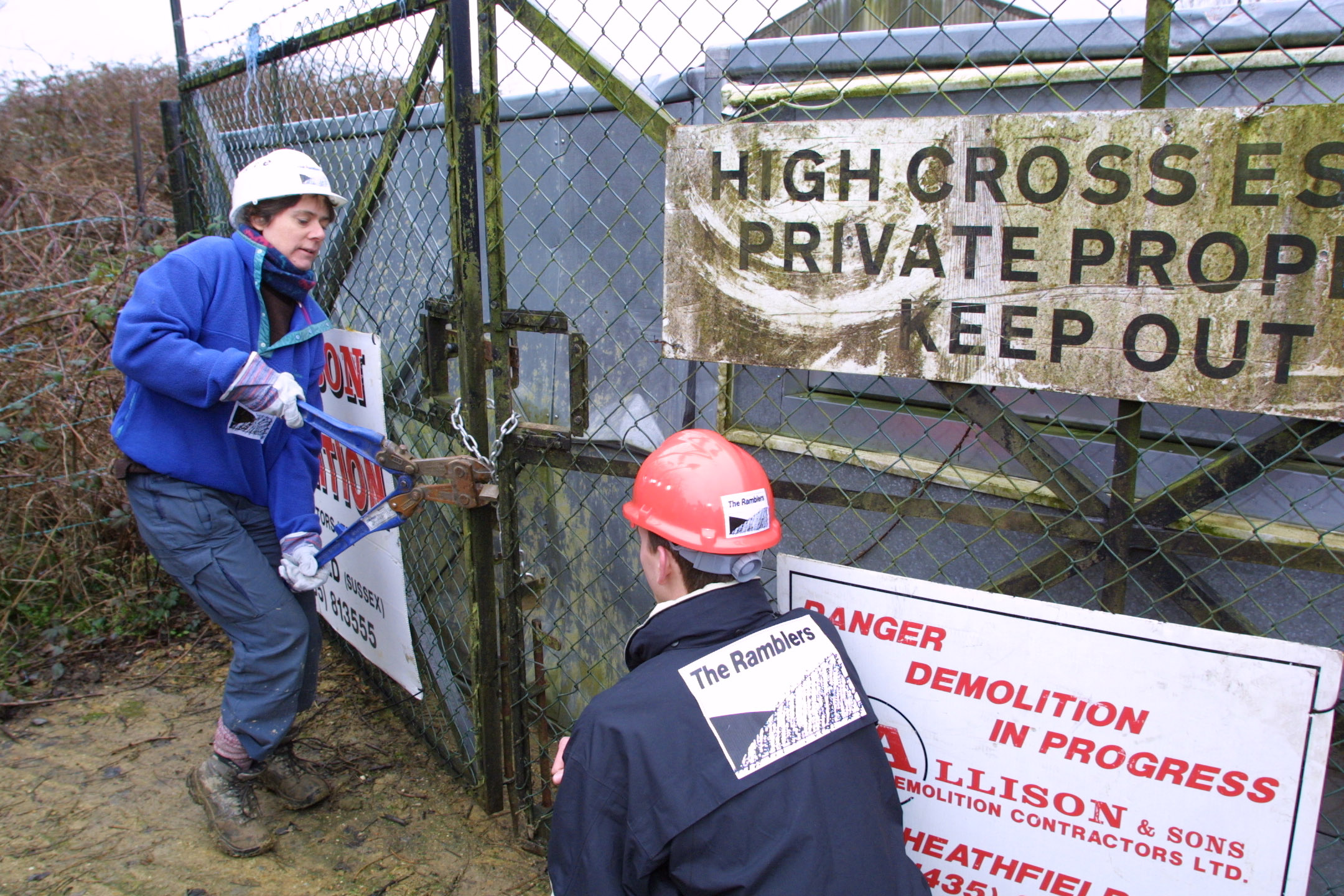 Campaigners cutting bolts on the fence blocking the footpath to reopen it.