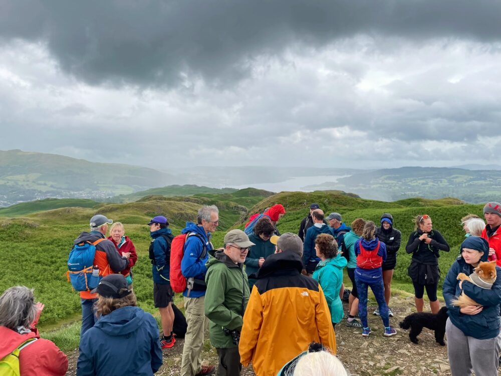 Several people standing chatting atop the fell