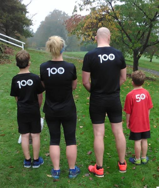 Image of 4 runners - 3 wearing black 100 parkrun T-shirts, one wearing a red 50 parkrun Tshirt